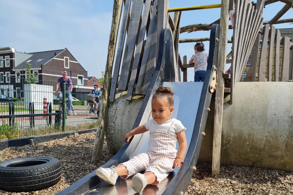 Glijbaan met meisje bij kinderopvang Werelds