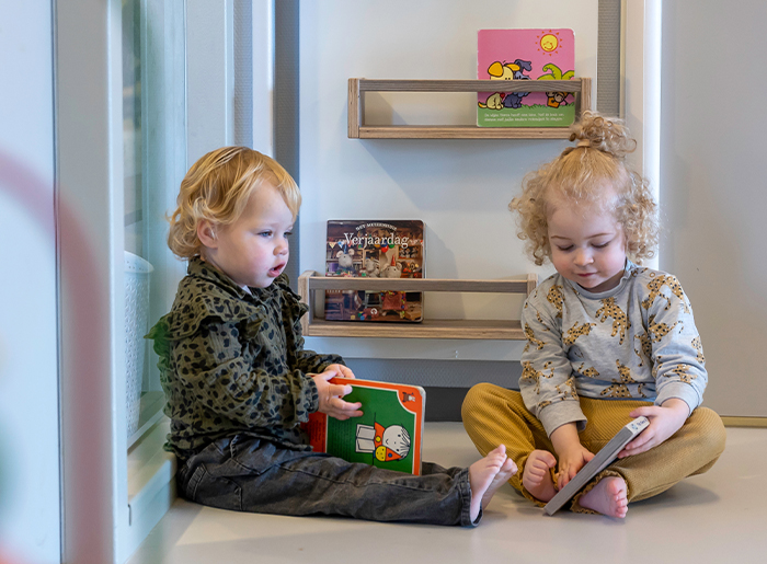 twee peuters lezen een boekje