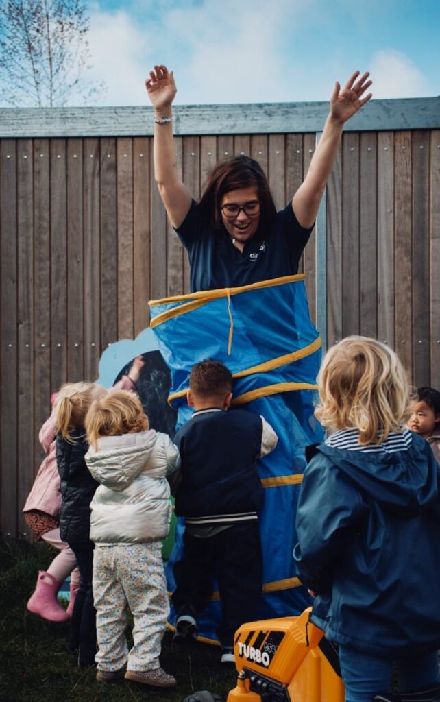 kinderen spelen buiten met pedagogisch professional van Dichtbij kinderopvang