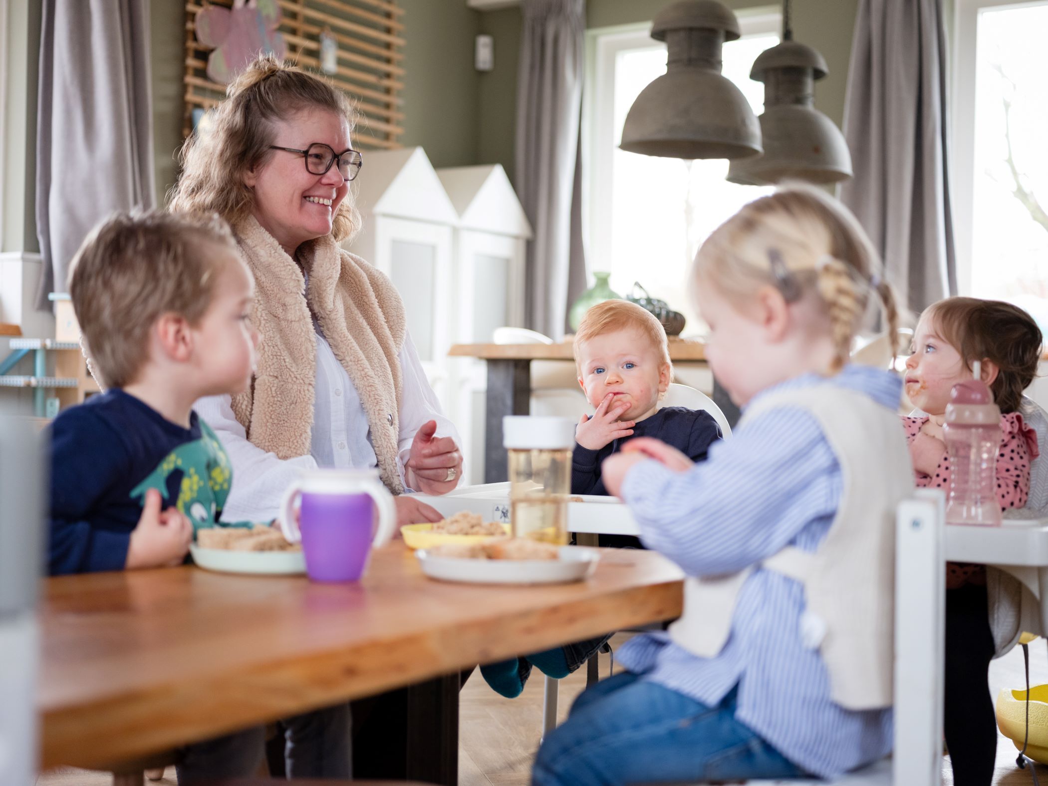 gastouders aan tafel met kinderen voor de lunch