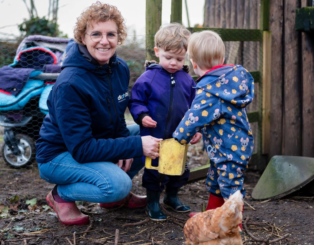 kinderen voeren de kippen samen met de gastouder